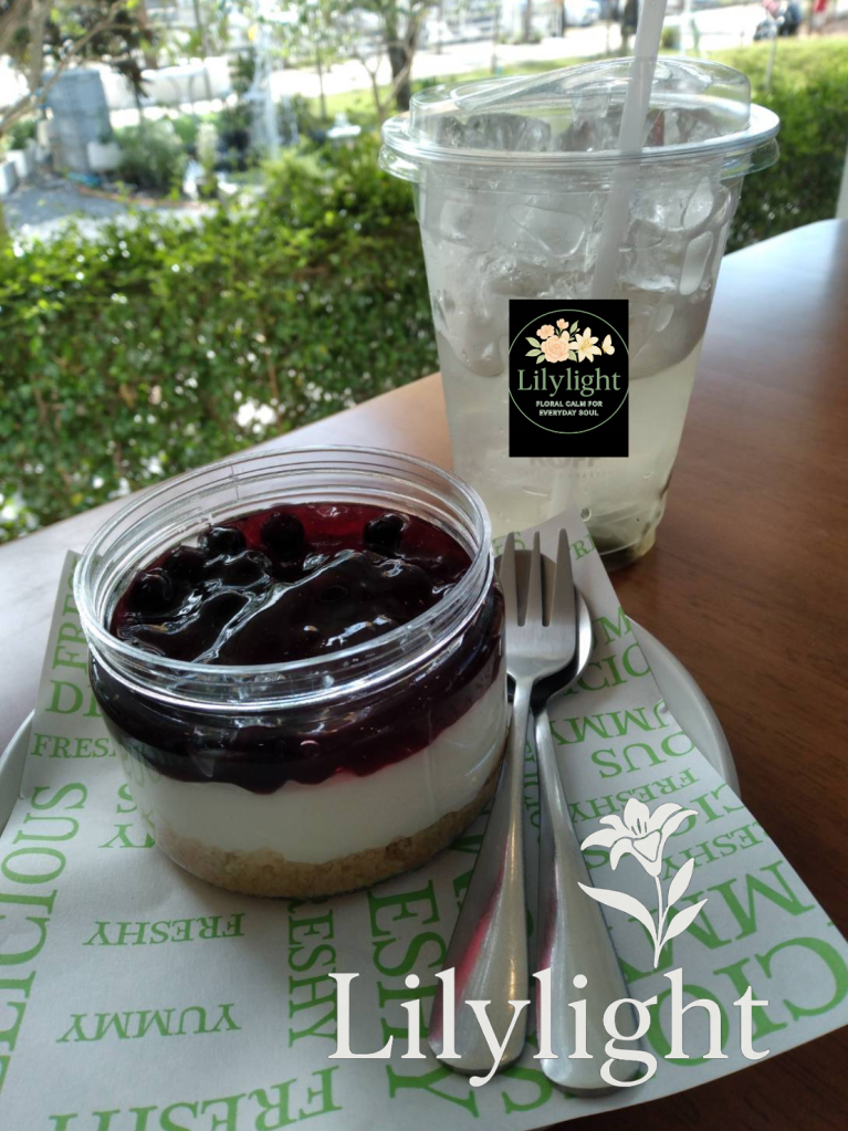 Blueberry cheesecake jar served with iced drink on a wooden table at a café.