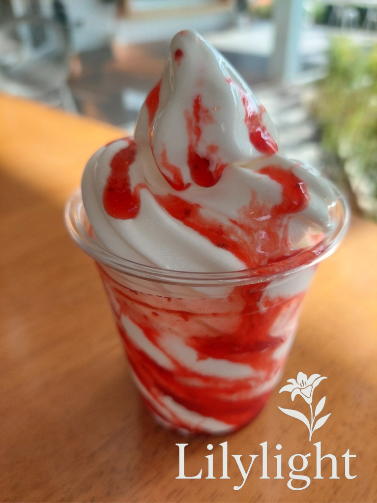 melting strawberry sundae in afternoon light on wood table