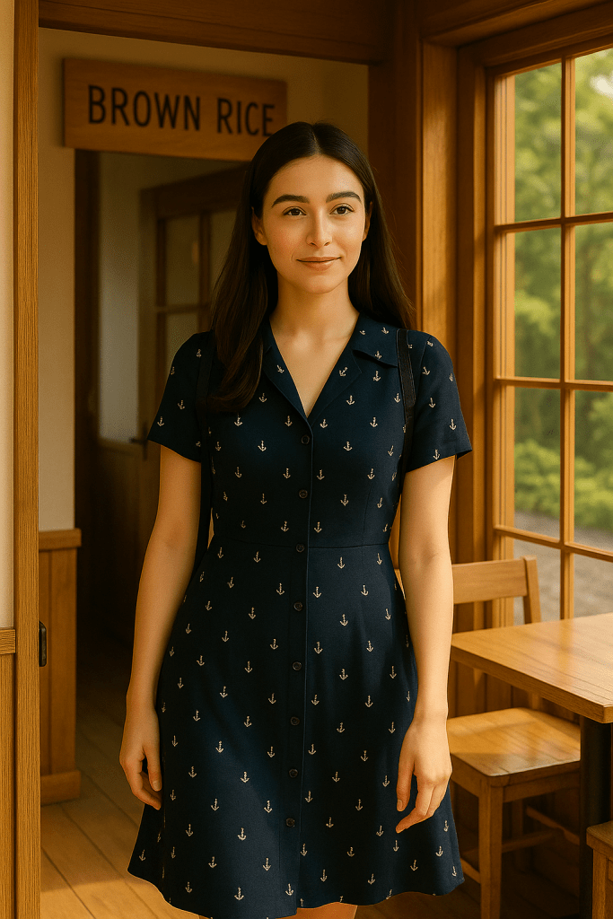 Natasha wearing a navy blue dress with small white anchor patterns, standing gracefully at the entrance of a wooden-style restaurant in Shirokane, Tokyo.