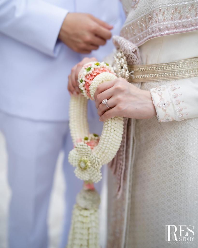 Bride holding a traditional Thai jasmine garland during a wedding ceremony, symbolizing love, respect, and lifelong commitment.