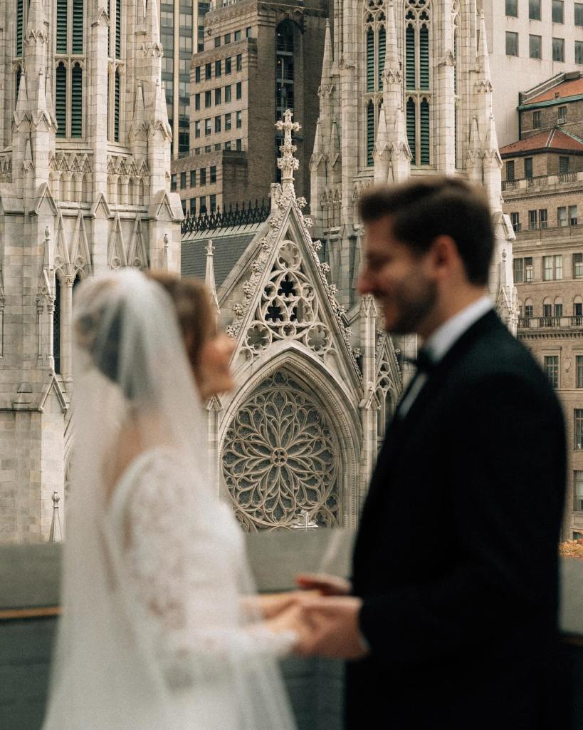 Bride and groom holding hands during a wedding ceremony in front of St. Patrick’s Cathedral in New York City